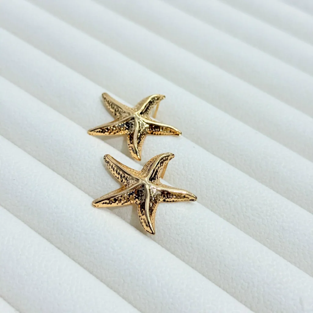 RINGO gold starfish earrings on white background - elegant ocean inspired jewelry for women